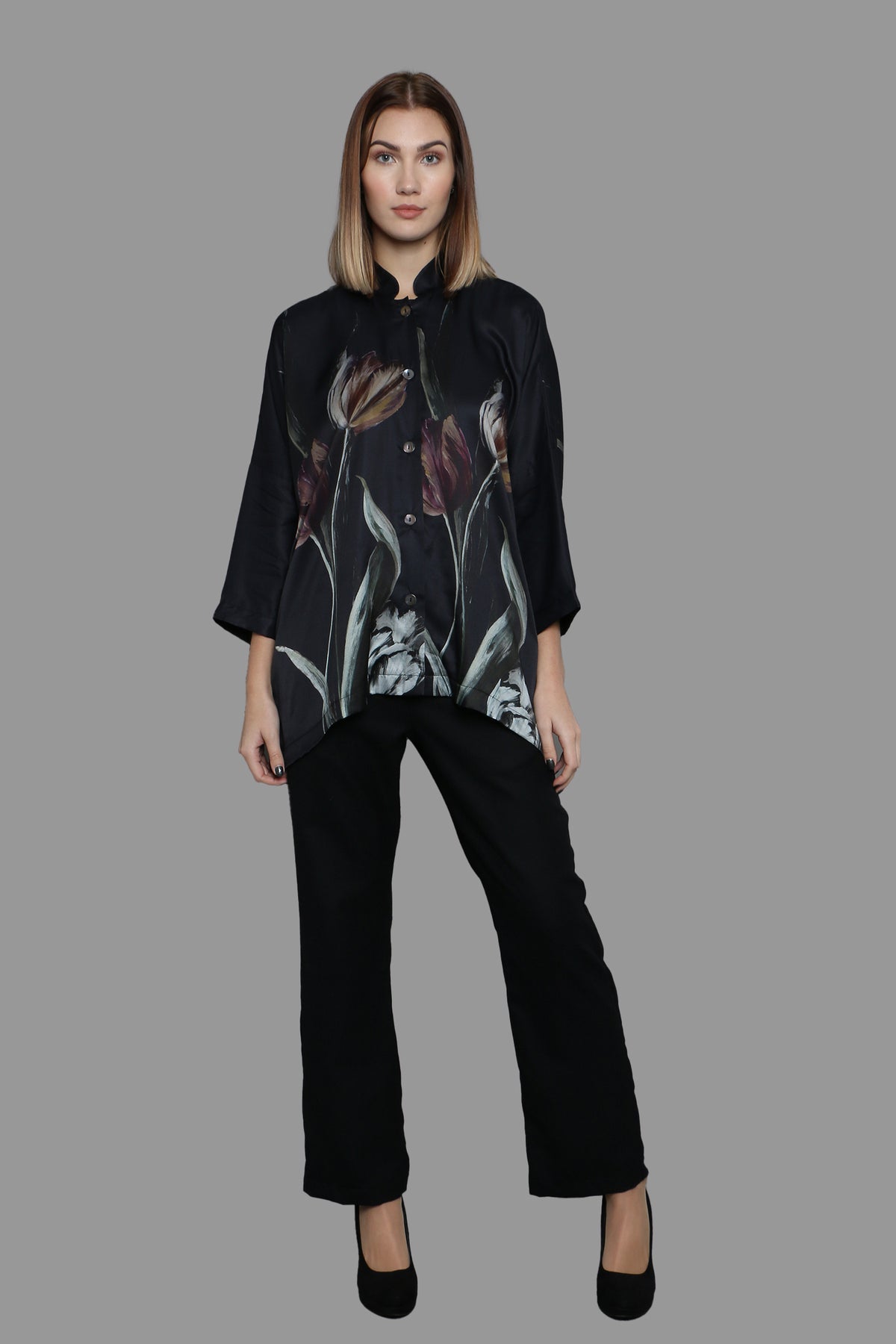 Full body picture of a lady wearing printed shirt and trouser all black